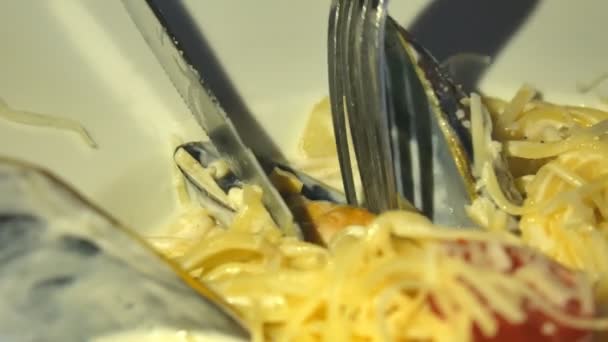 З'їдає поруч з карбонара італійську пасту з сиром Пармезан і мідіями. — стокове відео