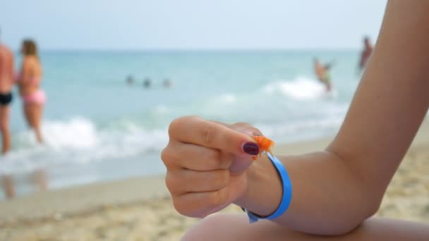 En flicka sitter på stranden och äter räkor med händerna. — Stockvideo