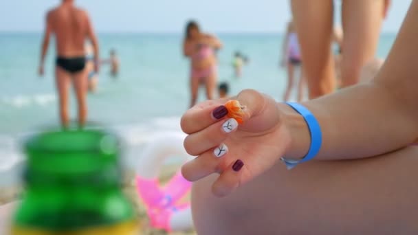 Bir kız sahilde oturuyor ve elleriyle karides yiyor. — Stok video