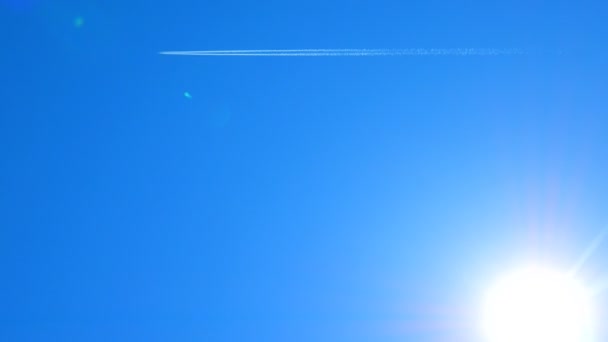 Vliegtuig track op een blauwe hemel met zonsondergangen, achtergrond. — Stockvideo