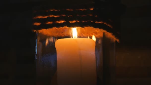 Kerze in einem Restaurant auf schwarzem Hintergrund in einem Kerzenständer. — Stockvideo