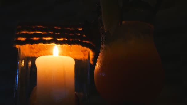 Kaars in een restaurant op een zwarte achtergrond in een kandelaar in de buurt van de cocktail, op het strand — Stockvideo