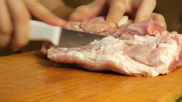 Женщина режет мясо ножом на мелкие кусочки на доске . — стоковое видео