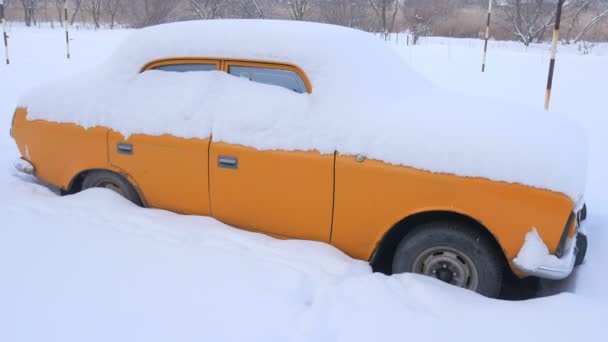 Bil täckt av snö, under sträng vinterstorm. Bilar på gården under snön. — Stockvideo