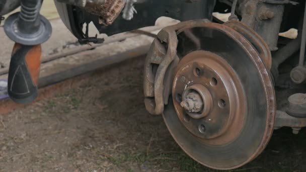 Männlich reinigt rostfreien Bremssattel, bevor er das Rad ersetzt. — Stockvideo