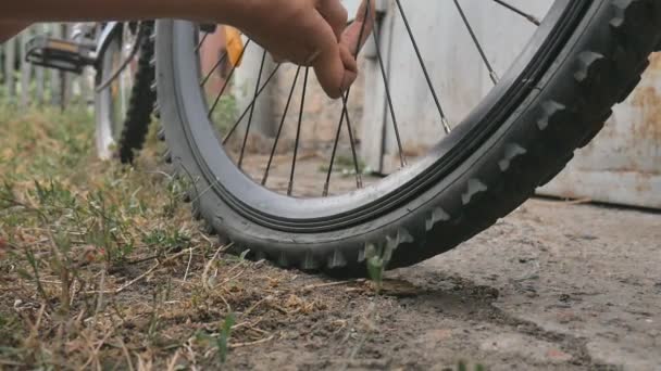 Девушка сломала колесо велосипеда. Ремонт велосипедов. Велосипедист ремонтирует велосипед. Дыра в колесе . — стоковое видео