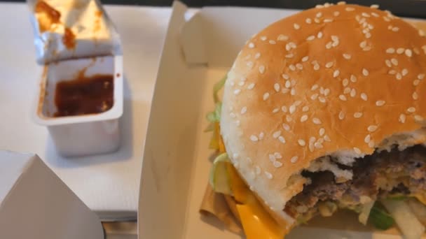 Гамбургер Биг Мак с картошкой фри, кетчупом, соусом чили в ресторане . — стоковое видео