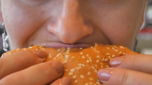 Chica comiendo una hamburguesa. Primer plano de tiro. La comida rápida come. Hamburguesa en manos femeninas. — Vídeos de Stock