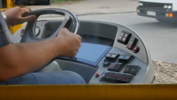 Kyjev Ukrajina - 7. července2019. Detailní záběr řidiče autobusu nebo autokaru ruce na volantu a palubní desce při jízdě na rušné městské ulici. — Stock video