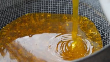 Bal çıkarıcıdaki bal, besleme yoluyla filtreleniyor. Kevgire sürülen baldan bal akar..