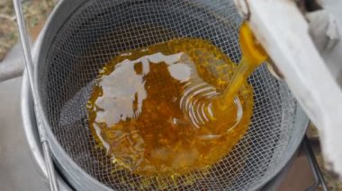 Bal çıkarıcıdaki bal, besleme yoluyla filtreleniyor. Kevgire sürülen baldan bal akar..