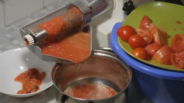 Výroba domácí čerstvé rajčatové šťávy s elektrickým strojem. Oddělení kůry a semen od rajčatové šťávy. — Stock video