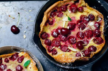 Kiraz Hollandalı bebek, Puff Alman gözleme Vintage tava ve koyu arka plan, yaz tatlı