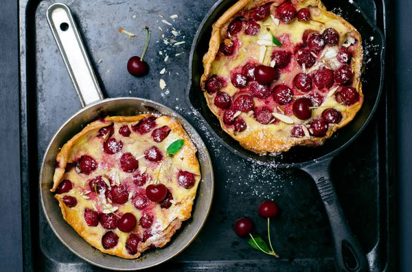 Kiraz Hollandalı bebek, Puff Alman gözleme Vintage tava ve koyu arka plan, yaz tatlı