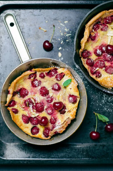 Kiraz Hollandalı bebek, Puff Alman gözleme Vintage tava ve koyu arka plan, yaz tatlı