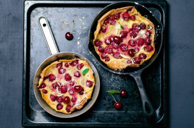 Kiraz Hollandalı bebek, Puff Alman gözleme Vintage tava ve koyu arka plan, yaz tatlı