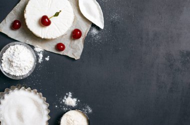 Süt ürünleri, un, şeker ve siyah arka plan, kopya alanı üzerinde kiraz