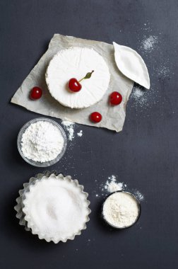 Süt ürünleri, un, şeker ve siyah arka plan, kopya alanı üzerinde kiraz