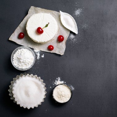 Süt ürünleri, un, şeker ve siyah arka plan, kopya alanı üzerinde kiraz