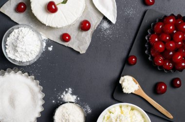 Süt ürünleri, un, şeker ve siyah arka plan, kopya alanı üzerinde kiraz