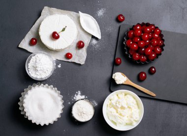 Süt ürünleri, un, şeker ve siyah arka plan, kopya alanı üzerinde kiraz