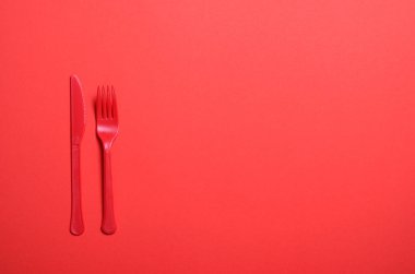 Kırmızı çatal ve bıçak parlak turuncu arka planda, kişilik çatal bıçak takımı