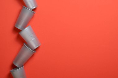 Tek Kişilik Kullanım plastik bardak, parlak turuncu arka plan gıda kavramı üzerinde gri plastik bardak