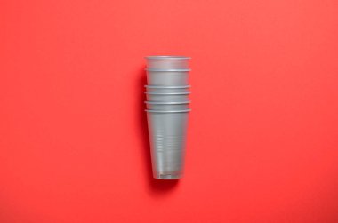 Tek Kişilik Kullanım plastik bardak, parlak turuncu arka plan gıda kavramı üzerinde gri plastik bardak