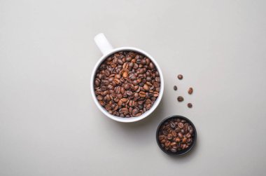 Kahve çekirdekleri kupa kahve kavramı parlak bej renkli arka plan üzerinde