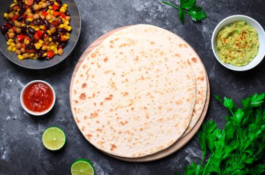 Sade tortilla domates Salsa, Guacamole ve koyu arka plan, leziz buğday ekmeği, Meksika yemeği üzerinde taze maydanoz ile
