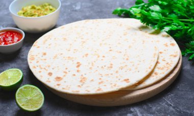 Sade tortilla domates Salsa, Guacamole ve koyu arka plan, leziz buğday ekmeği, Meksika yemeği üzerinde taze maydanoz ile