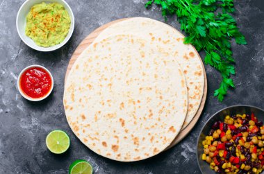 Sade tortilla domates Salsa, Guacamole ve koyu arka plan, leziz buğday ekmeği, Meksika yemeği üzerinde taze maydanoz ile