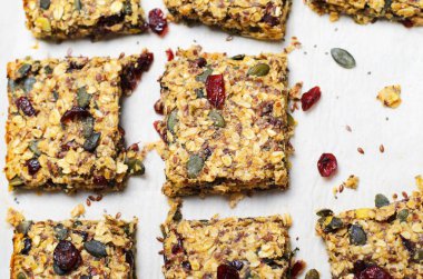 Granola barlar, sağlıklı ev yapımı Snack, kızılcık, kabak çekirdeği, yulaf, Chia ve keten tohumu parlak arka planda, Vegan Yemek çubuklarıyla Superfood