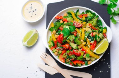 Taze sebze salatası, avokado, nohut, biber, salatalık, ıspanak ve giyinme, sağlıklı tahin ile Sağlıklı Vegan yemek yeme