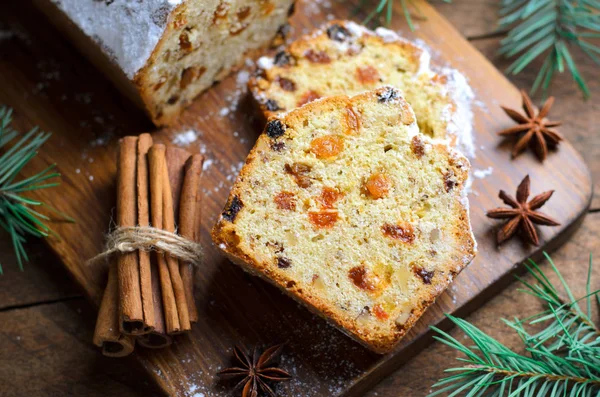 Fruit Loaf Cake Dusted with Icing Sugar, Christmas and Winter Holidays Treat, Homemade Cake with Raisins on Wooden Background