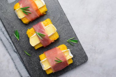 Polenta ısırıkları ile Prosciutto ve Brie veya Camembert peyniri, Polenta meze, lezzetli Snack, üstten görünüm