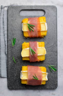 Polenta ısırıkları ile Prosciutto ve Brie veya Camembert peyniri, Polenta meze, lezzetli Snack, üstten görünüm