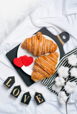 Romantik Odaya Servis yatak, kruvasan, aşk mektupları üzerinde beyaz çarşaf, üstten görünüm