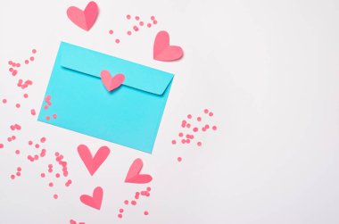 Pembe kalpler ve zarfın üzerinde beyaz arka plan, kopya alanı, üstten görünüm