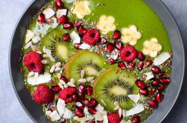 Sağlıklı kahvaltı detoks tohum ve meyve bir kase, Vegan Yemek, en iyi görünümü ile Yeşil Smoothie muz ve ıspanak ile tepesinde