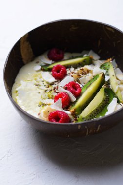 Ahududu, kivi, Chia, keten tohumu ve Hindistan cevizi, Matcha yeşil çay Vegan Yemek ile tepesinde güler yüzlü kase