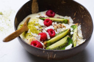 Ahududu, kivi, Chia, keten tohumu ve Hindistan cevizi, Matcha yeşil çay Vegan Yemek ile tepesinde güler yüzlü kase