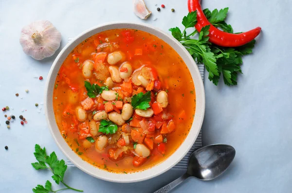 Vegetable Soup with White Beans, Homemade Soup on Bright Background, Vegetarian Food, Top View