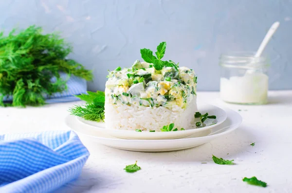 Рисовый салат с огурцами, яйцами, кислым кремом и травами — стоковое фото