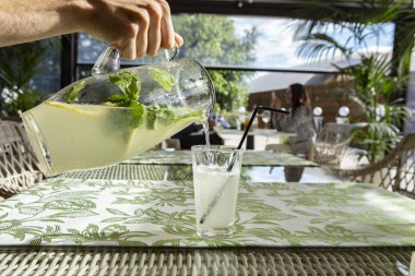 Limonata limon, nane ve buz. Cam içine dökme limonata genç adam.