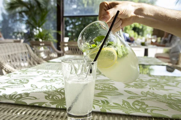 Limonata limon, nane ve buz. Cam içine dökme limonata genç adam.