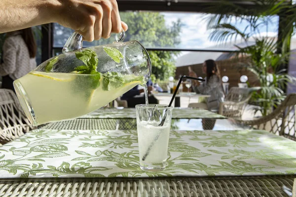 Limonata limon, nane ve buz. Cam içine dökme limonata genç adam.