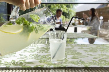 Limonata limon, nane ve buz. Cam içine dökme limonata genç adam.