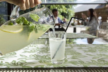 Limonata limon, nane ve buz. Cam içine dökme limonata genç adam.