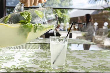 Limonata limon, nane ve buz. Cam içine dökme limonata genç adam.